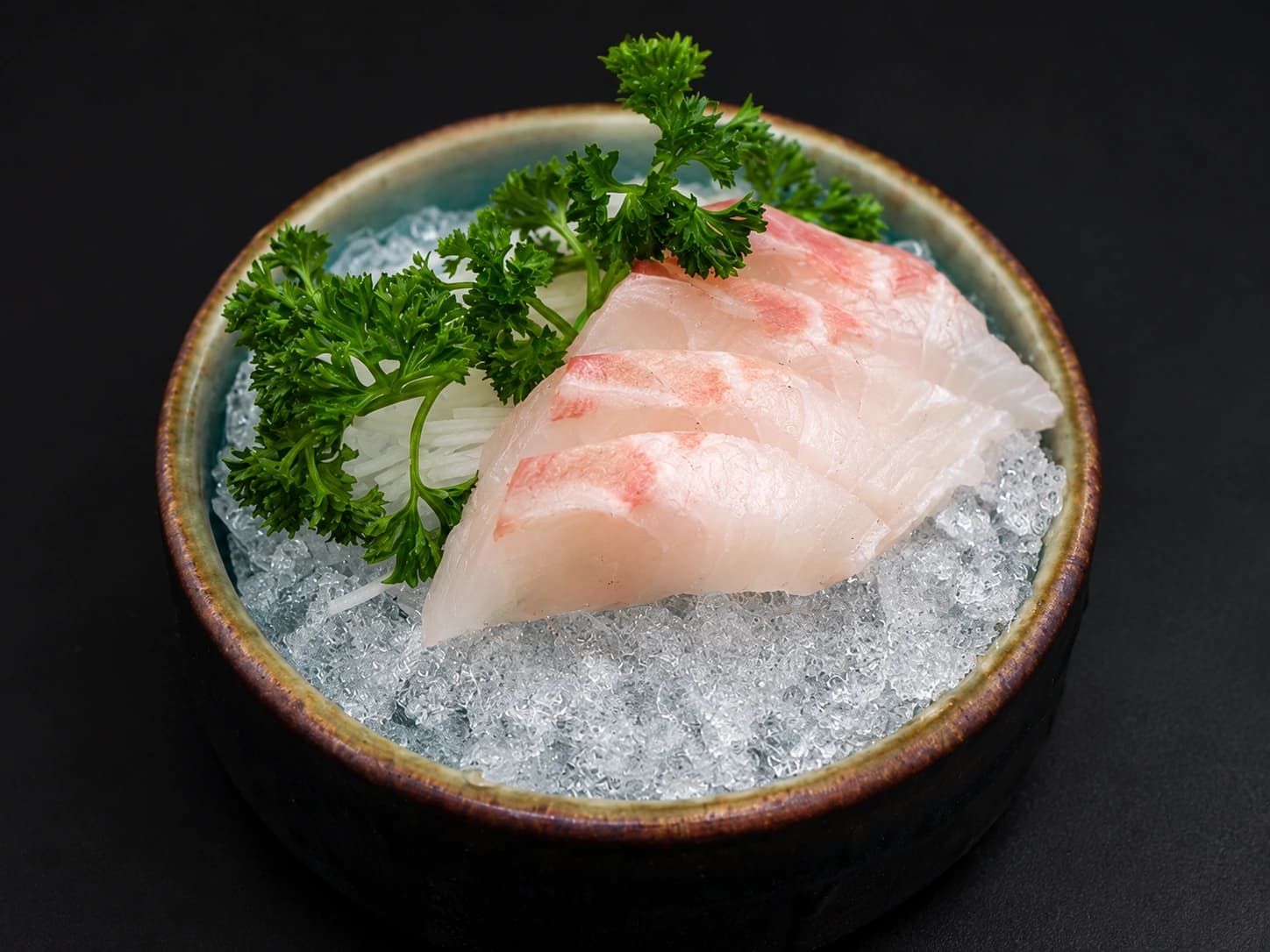 Fatias de sashimi de robalo sobre gelo